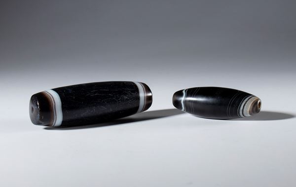 Lot of two tubular beads in black and white zoned agate. Tibet, 19th century