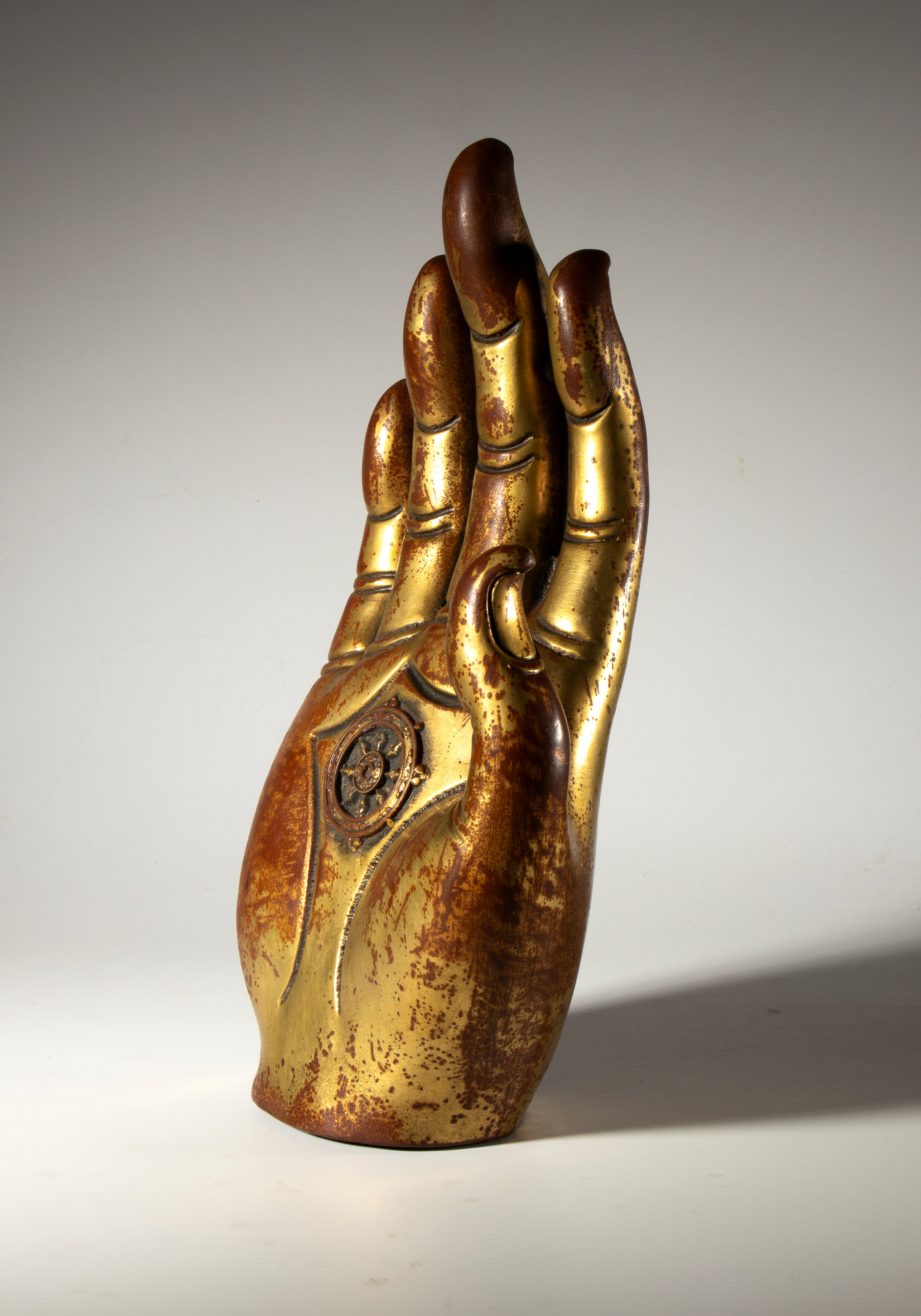Mano di Buddha in rame parzialmente dorato. Al centro del palmo la ruota del dharma. Birmania, XX...