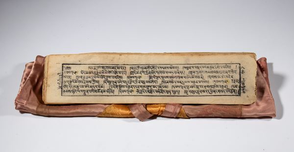 A Buddhist scripture book used for copying and reading sacred texts. Woodblock ink on rice paper with a silk brocade case. Tibet, 19th century.
