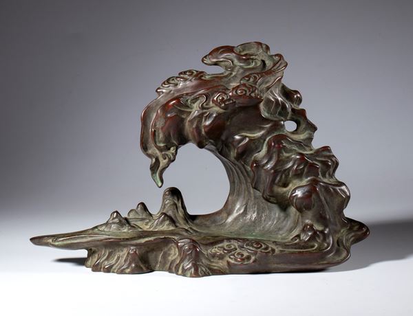 A copper alloy sculpture base depicting a rock amid clouds. China, 20th century