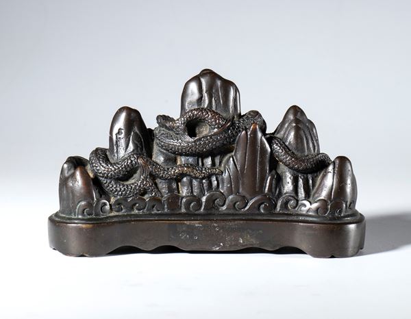 A copper-alloy brush holder in the shape of a mountain with a dragon. China, 19th century