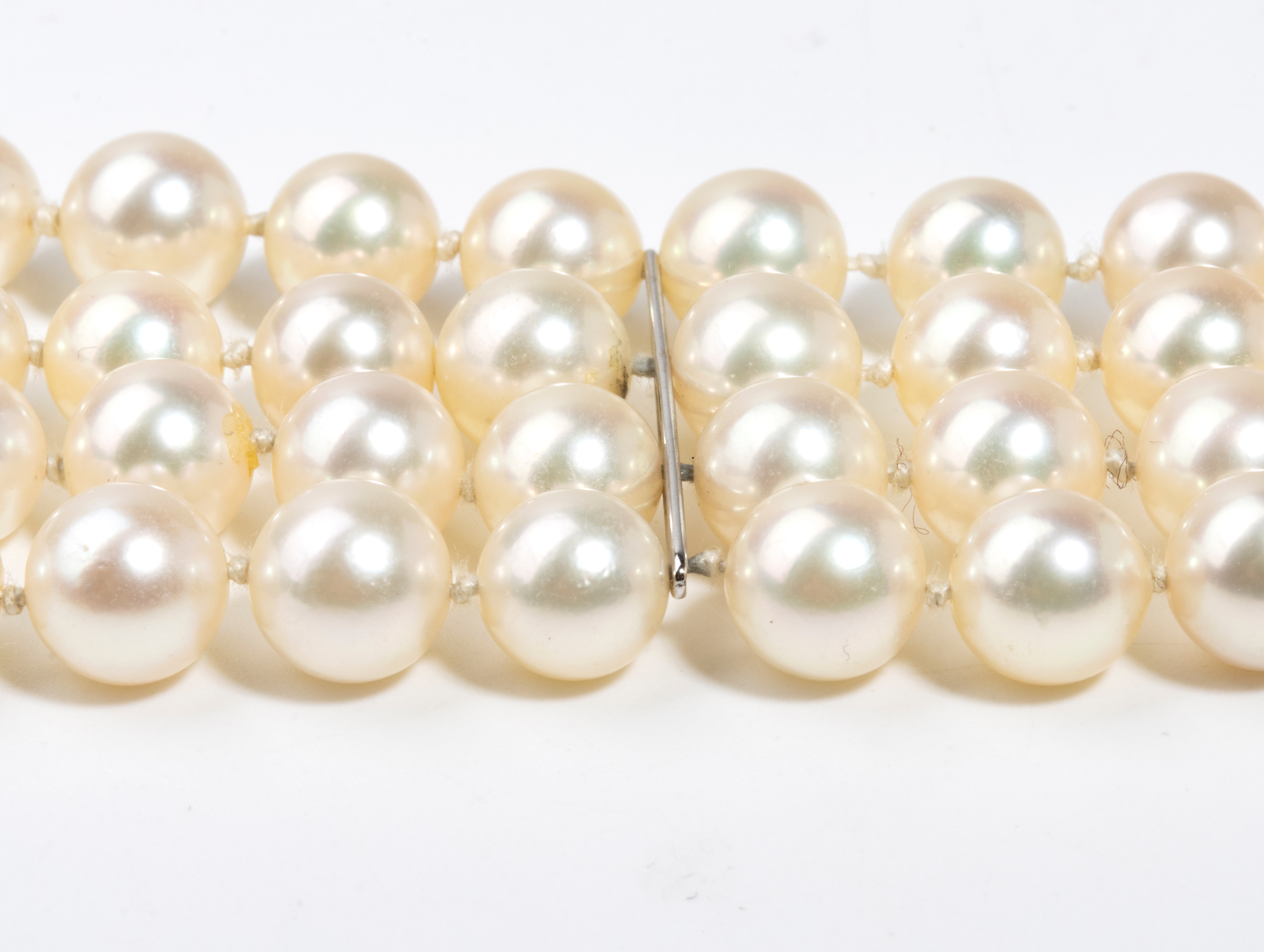 Bracciale a quattro fili di perle coltivate d’acqua salata in oro bianco, con smeraldi e diamanti