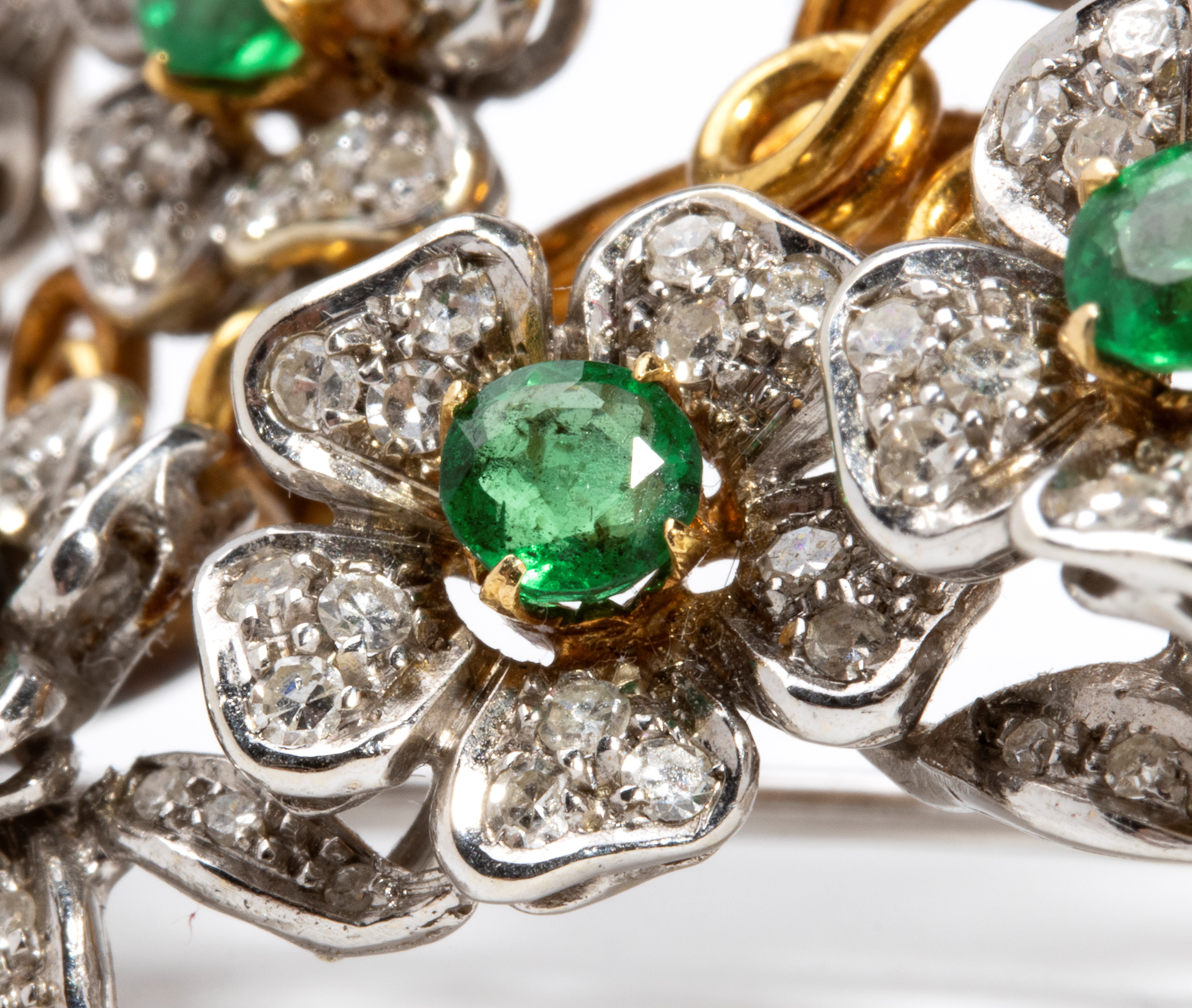 Spilla in oro bianco e oro giallo 18k con diamanti e smeraldi