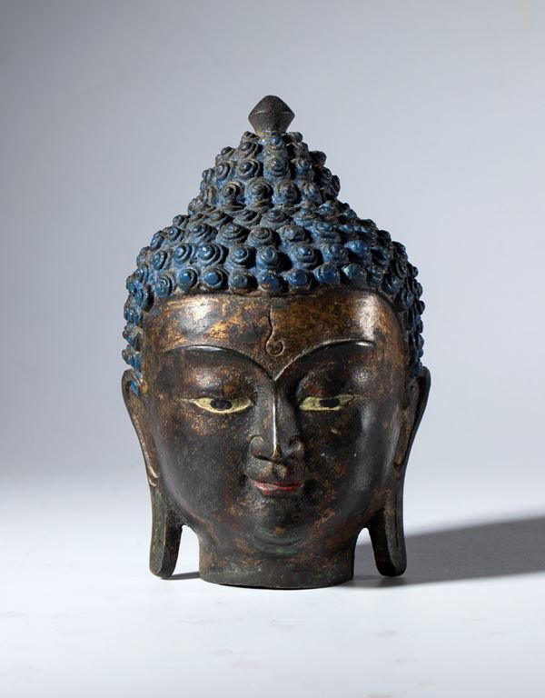 Partially painted copper alloy Buddha head. Himalayan region, 19th century.