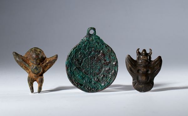 Lot of three copper alloy amulets consisting of a Jiu Gong Ba Gua and two Garuda figures. Tibet, XIX century