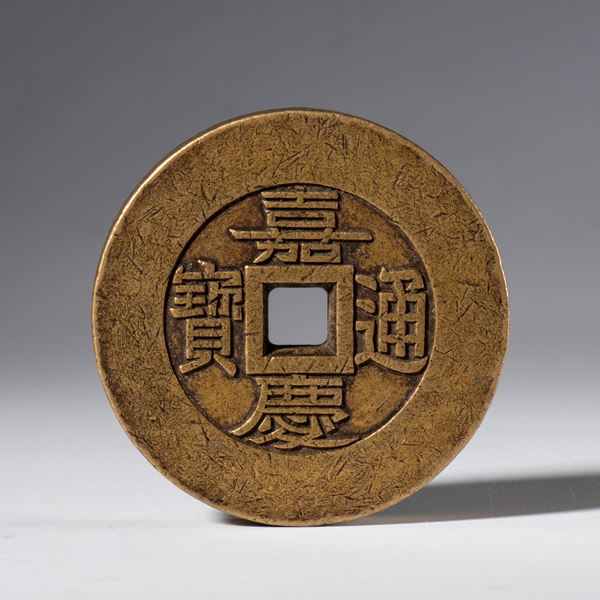 A copper paperweight in the shape of a Jia Qing Tongbao coin. China, 19th century.