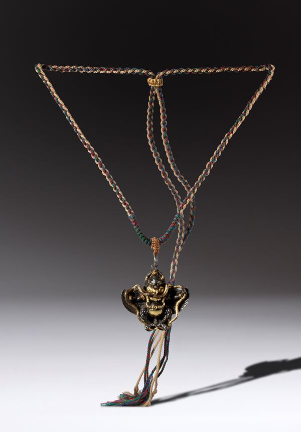 Partially gilded copper alloy pendant depicting Garuda. China, 20th century