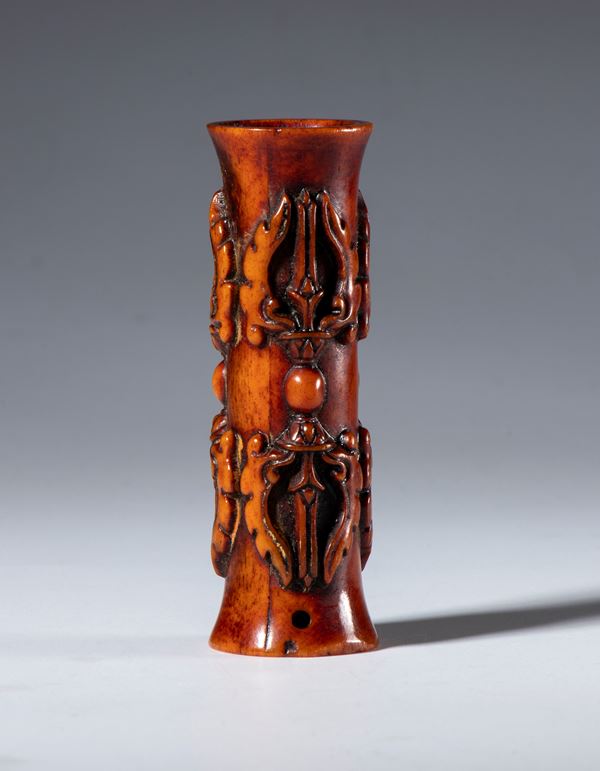 A tubular bone pendant carved with vajra-shaped elements. Tibet, 19th century