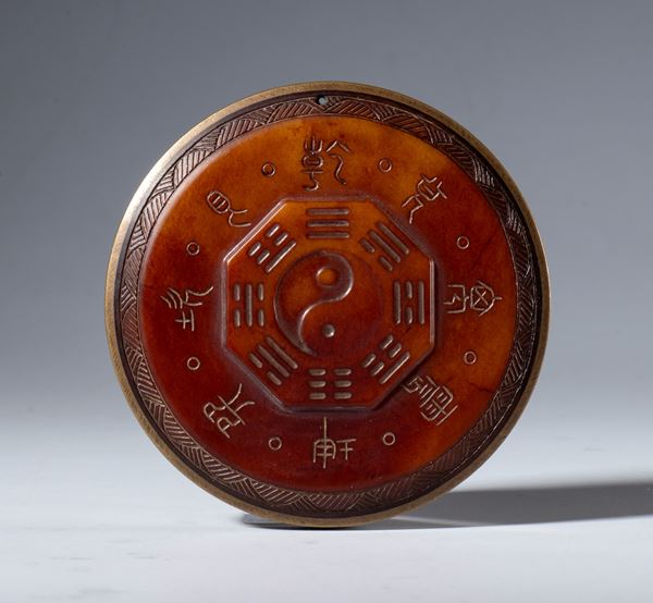 A Hotan red jade plaque with protective Taoist inscriptions. At the center is the symbol of the Tao surrounded by the eight trigrams of the I Ching. China, 19th century
