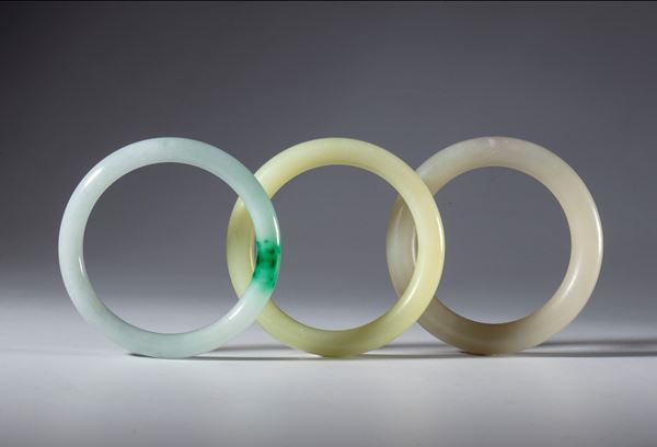 A lot of three ornamental bracelets in light jade and green jade. China, Qing Dynasty (1644–1911), 19th century.
