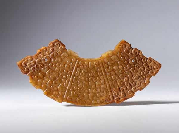 A Hotan jade half-disc ornament engraved with cloud motifs and two hanging hole. China, 19th century.