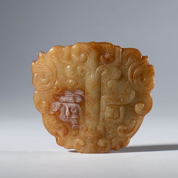 A Hotan jade ornamental pendant carved and engraved in the shape of a schematic dragon's head. China, 19th century.