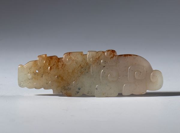 Ornamental pendant in Hotan jade carved and engraved in the shape of a schematic dragon. China, 17th century