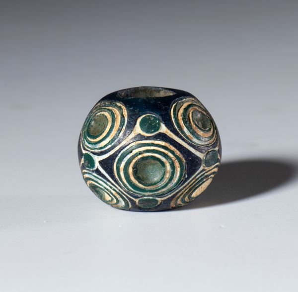 Antique opaque white-dark-blue glass bead with spiral motifs. China, Warring States Period (475–221 BC).