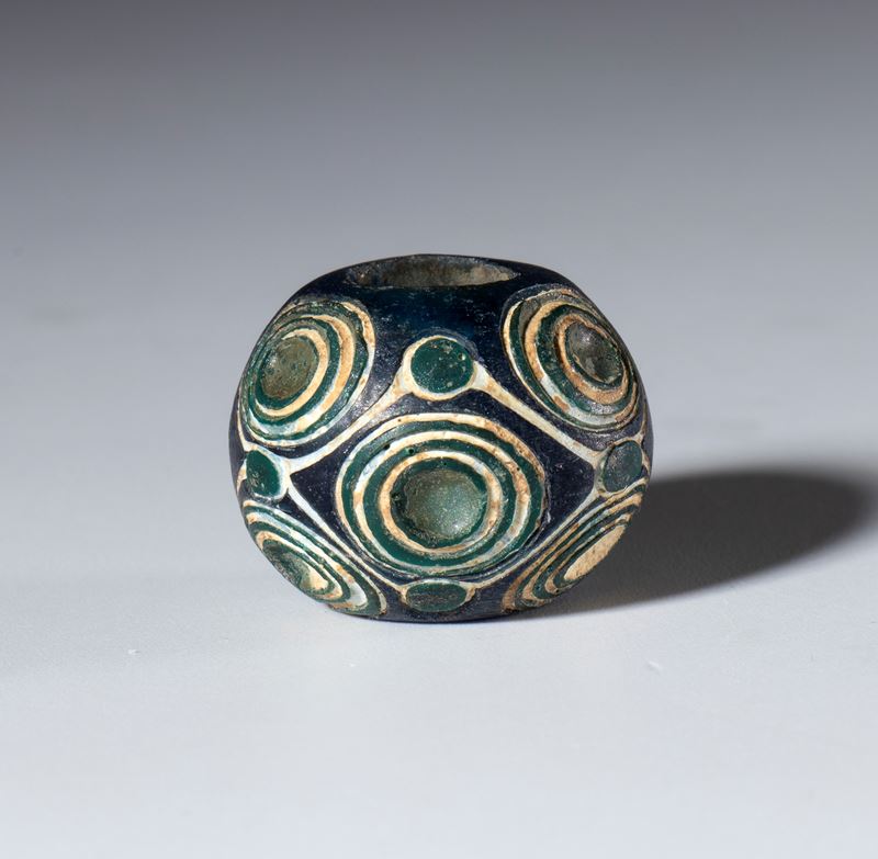 Perla antica, vetro opaco bianco con inserti blu scuro a motivi a spirale (Cina, Periodo degli St...