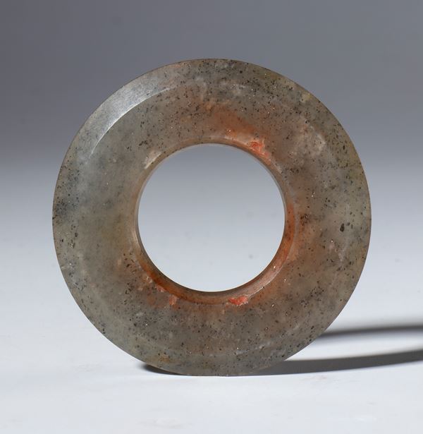 A BI disc of gray-red nephrite jade with flat edges. Transparency is not apparent. China, Qing Dynasty (1644-1912), late 19th century.