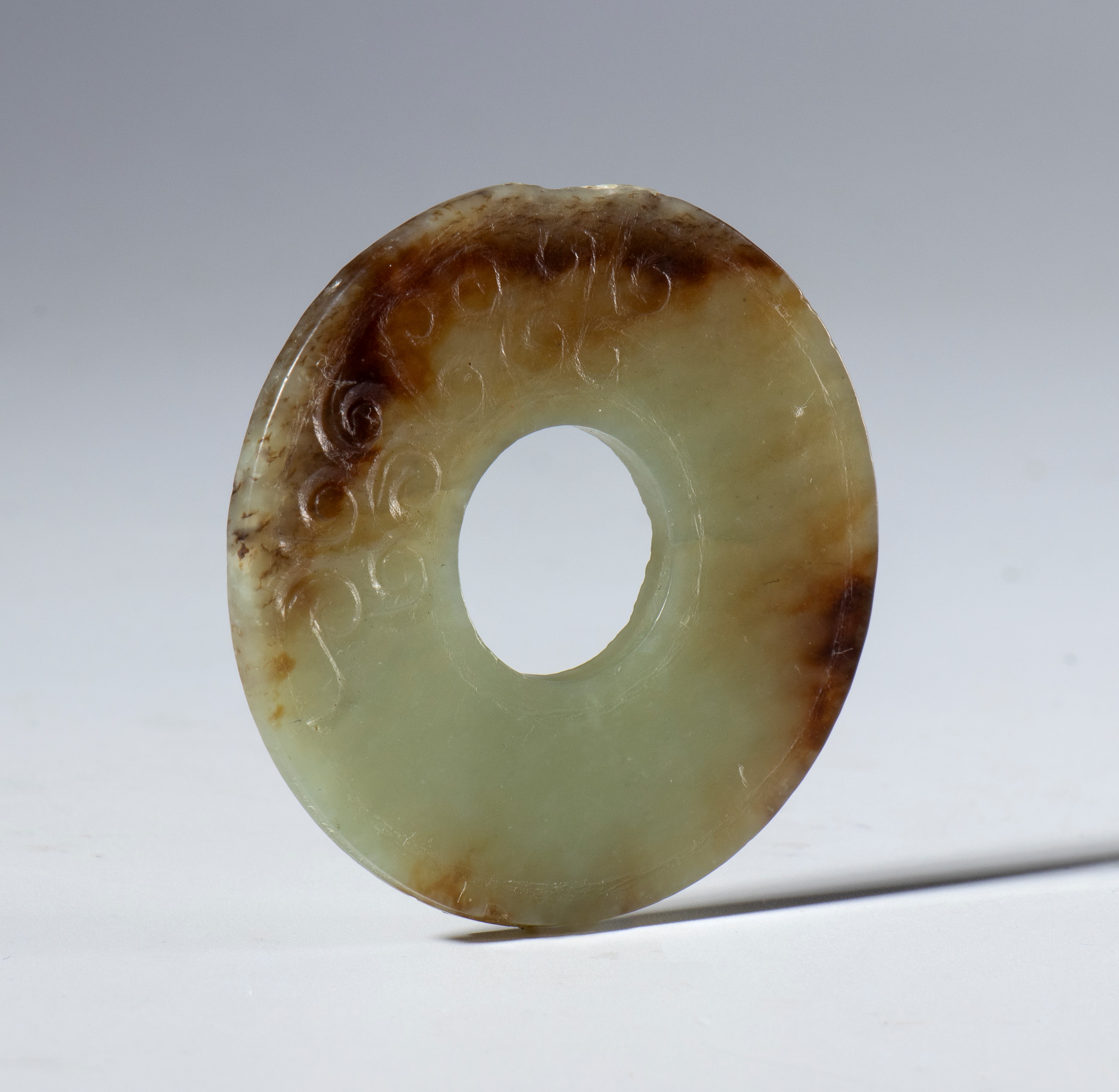 Cina, dinastia Qing (1644-1912), Fine XIX secolo, Bel disco in giada trasparente con screziature ...