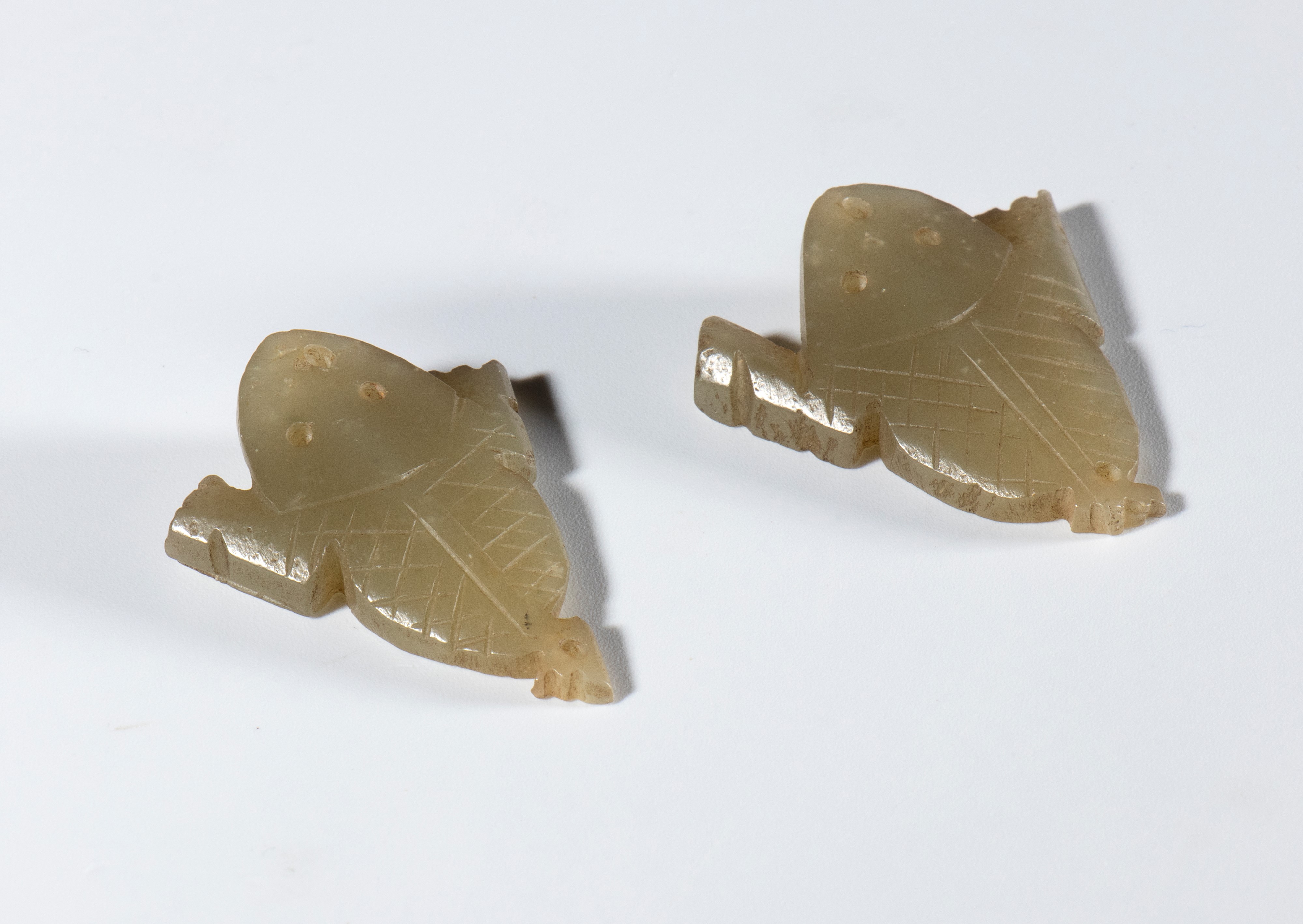Cina, dinastia Qing (fine XVIII-XIX secolo), Coppia di piccole placchette in giada chiara a forma...