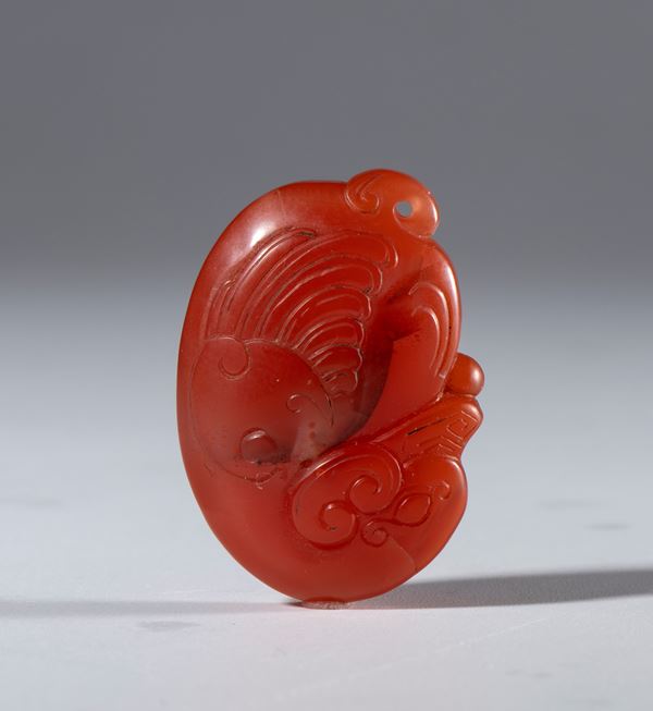 Nanhong agate pendant in the shape of a stylized bird with a hole for hanging. China, late 19th-early 20th century.