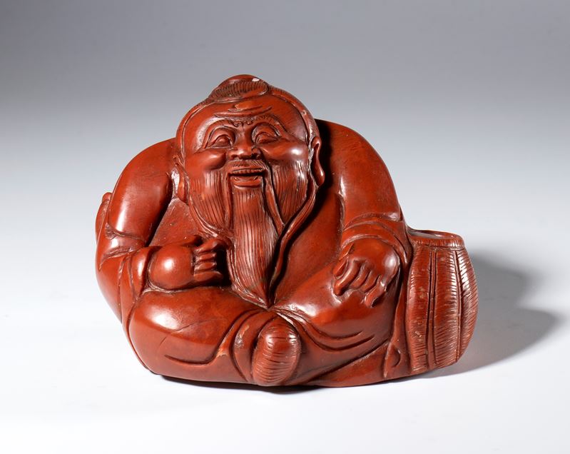 Figura di saggio scolpita e incisa in pietra saponaria rosso corallo. Cina, inizio XX secolo