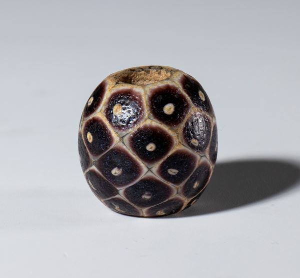 Antique spherical white glass and amethyst bead with snakeskin motifs. China.