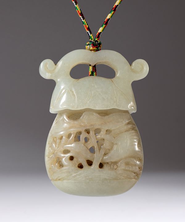 A carved and perforated jade pendant container. Used as an essence holder. Inside is a small piece of scented sandalwood. China, Qing Dynasty (1644-1912), late 18th century.