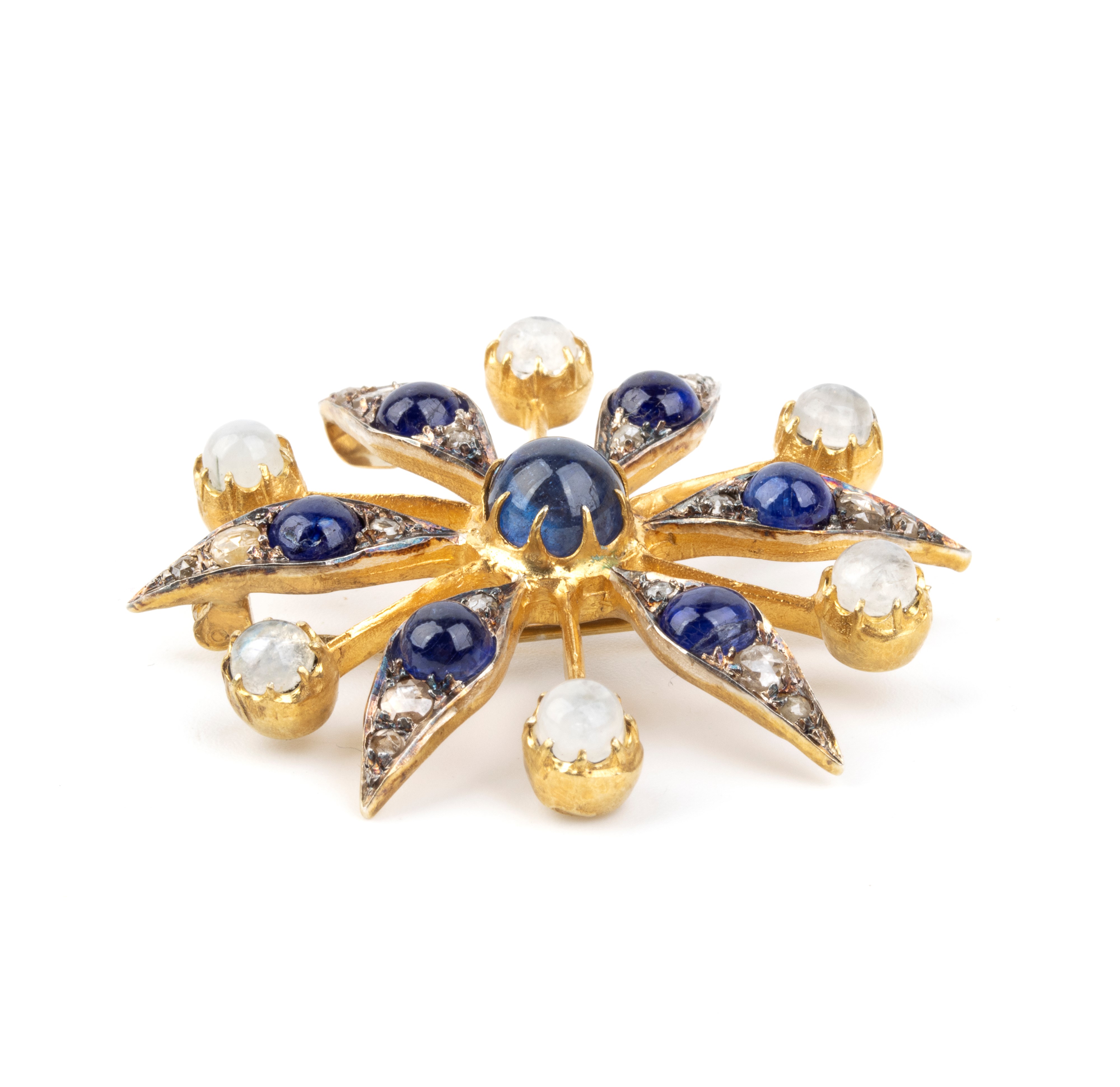 Spilla, motivo di fiore stilizzato in argento e oro giallo 14k, con zaffiri, pietra di luna e dia...
