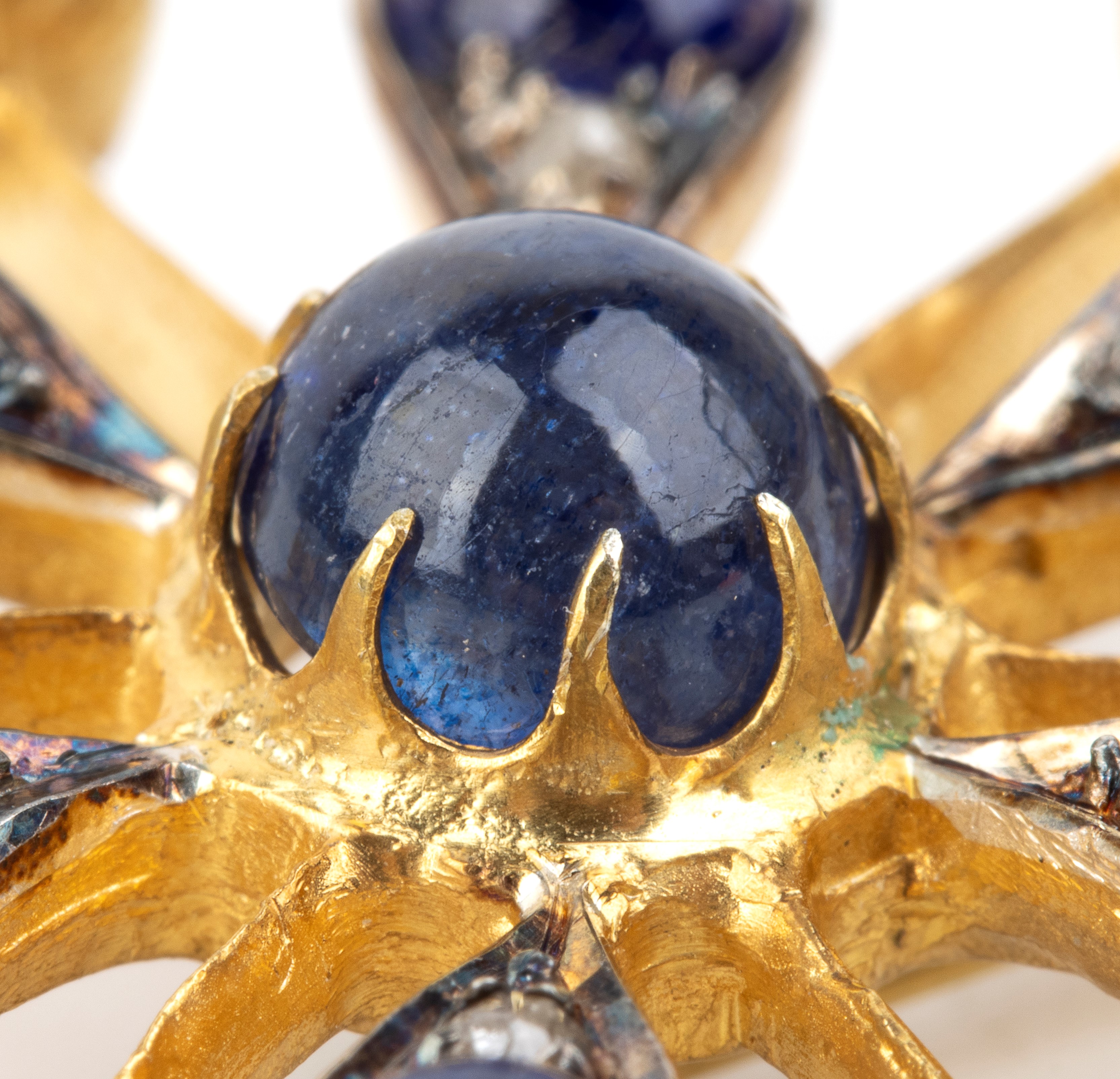 Spilla, motivo di fiore stilizzato in argento e oro giallo 14k, con zaffiri, pietra di luna e dia...