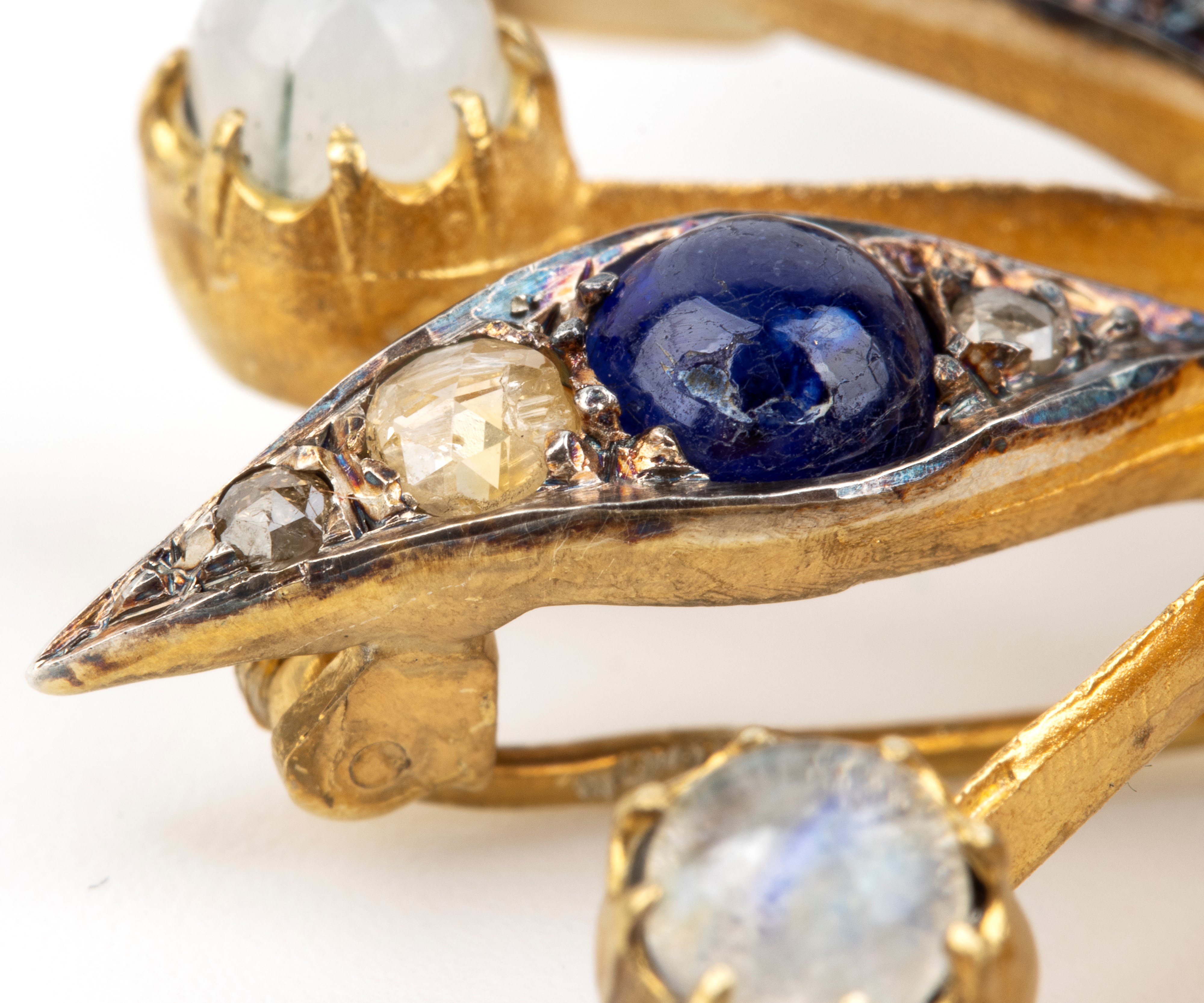 Spilla, motivo di fiore stilizzato in argento e oro giallo 14k, con zaffiri, pietra di luna e dia...