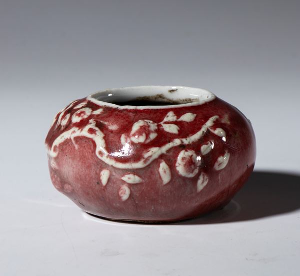 Small, low vase with plant decoration and oxblood glaze. China, 20th century.
