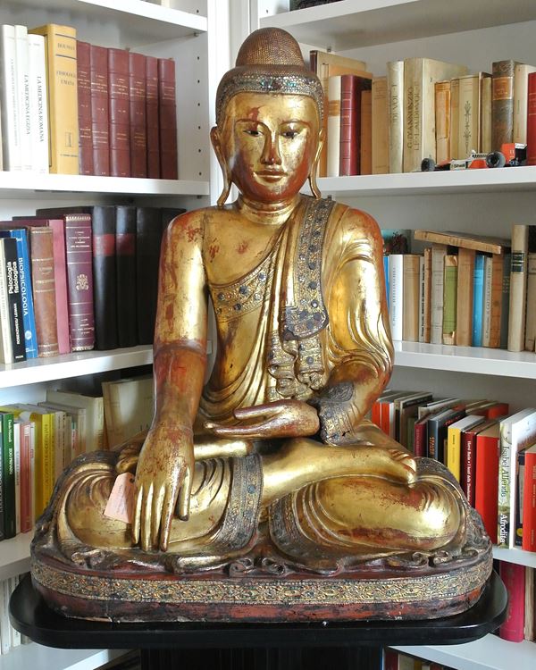 Buddha figure in the lotus position. Lacquered and gilded wood with stucco and glass paste applications, set on a wooden and black lacquer base. Burma, Mandalay, 19th century.