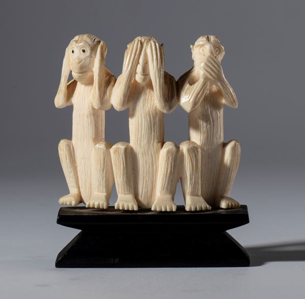 A small elephant ivory sculpture on a wooden base depicting the three monkeys Mizaru, Kikazaru, and Iwazaru. Japan, 19th century.