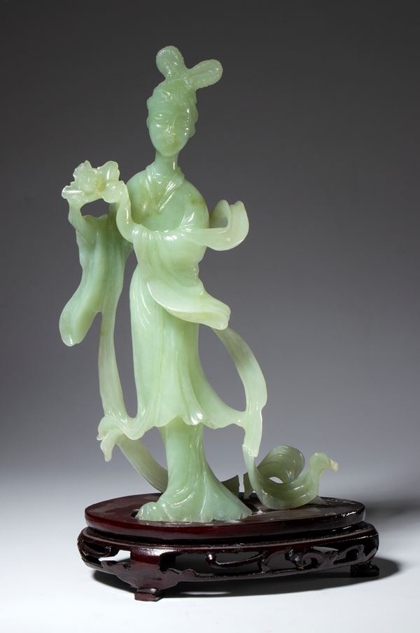 Green jade sculpture on a wooden base depicting a lady with a peony. China, 20th century.