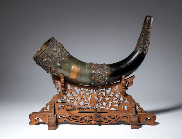 Large bovine horn with embossed and engraved metal appliques set with turquoise and coral. Openwork wooden base. China, 19th century.