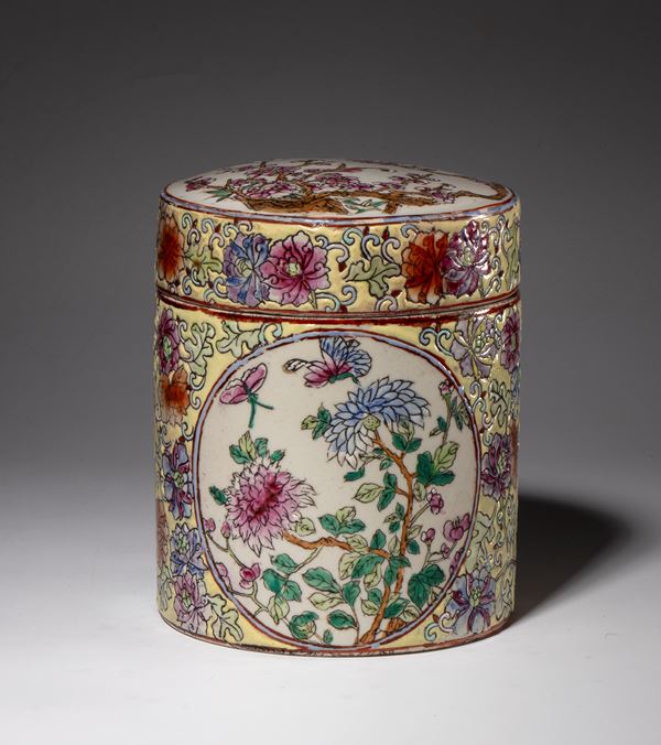 A cylindrical porcelain container with a lid decorated with plant motifs and medallions of peonies and butterflies. China, 20th century.