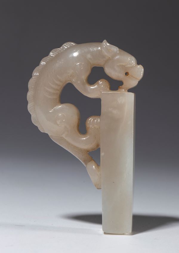 An unengraved jade stamp with a dragon figure. China, 20th century.