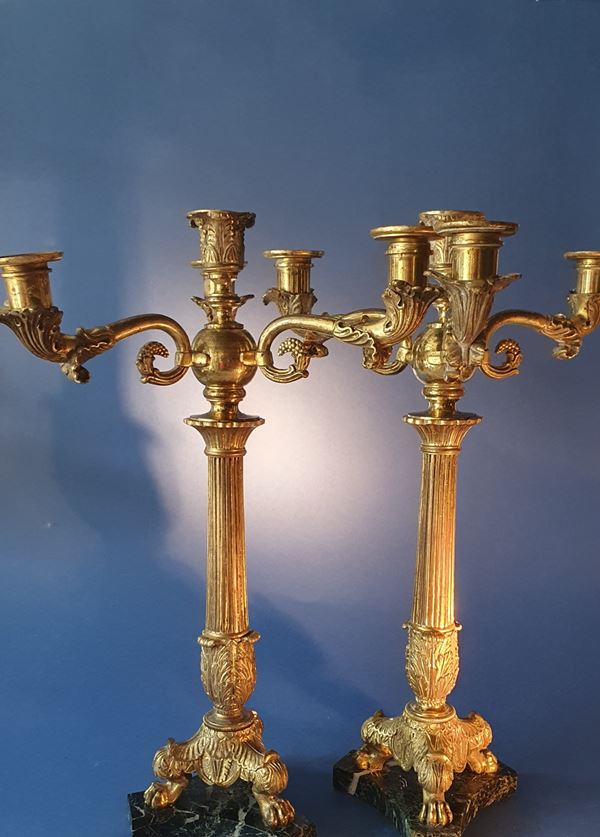 Pair of Empire candlesticks. Gilded bronze. First half of the 19th century. Slight chipping on the marble base. 
