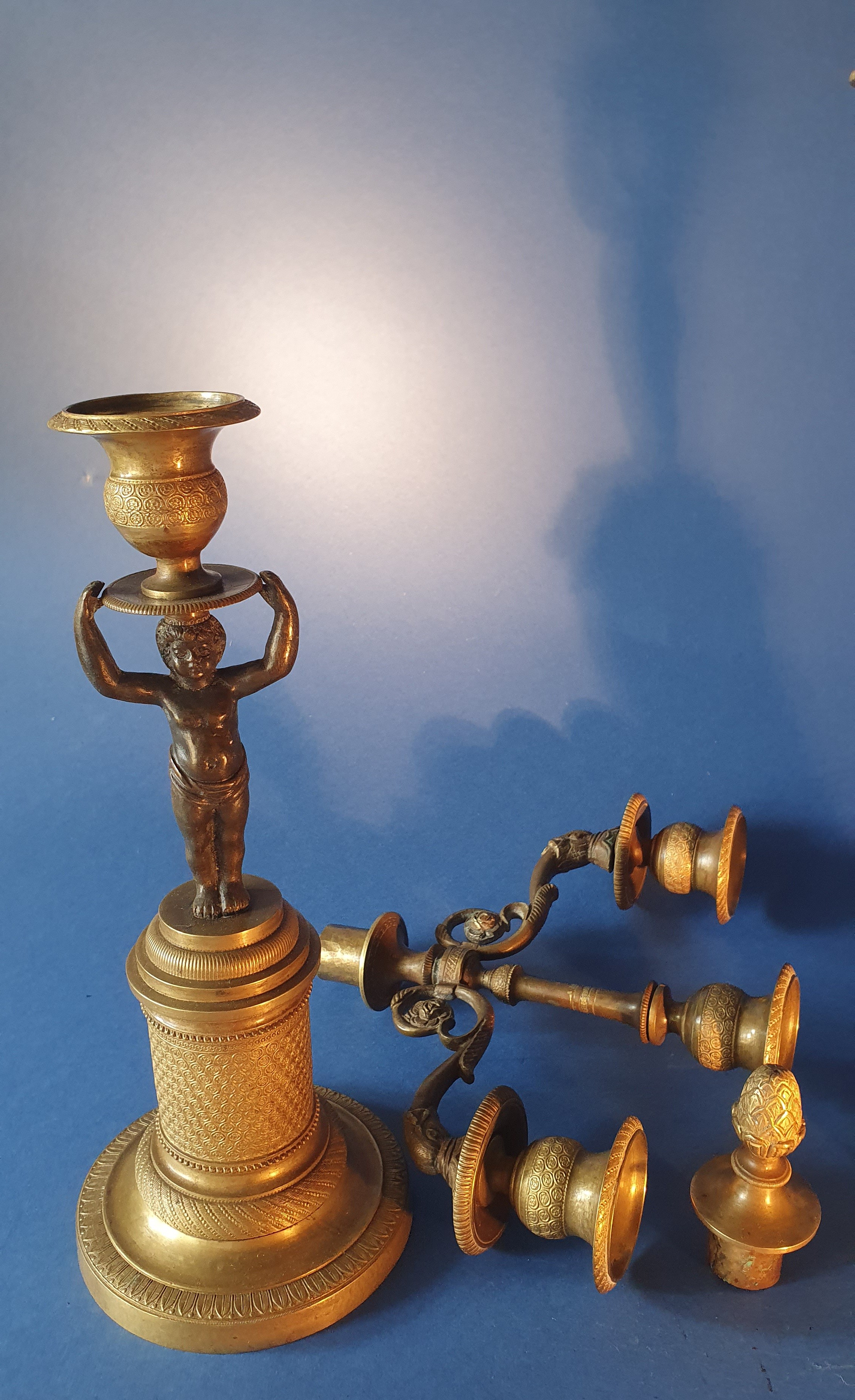 Coppia di candelieri con putti. Bronzo dorato e patinato nero. Primo XIX secolo.