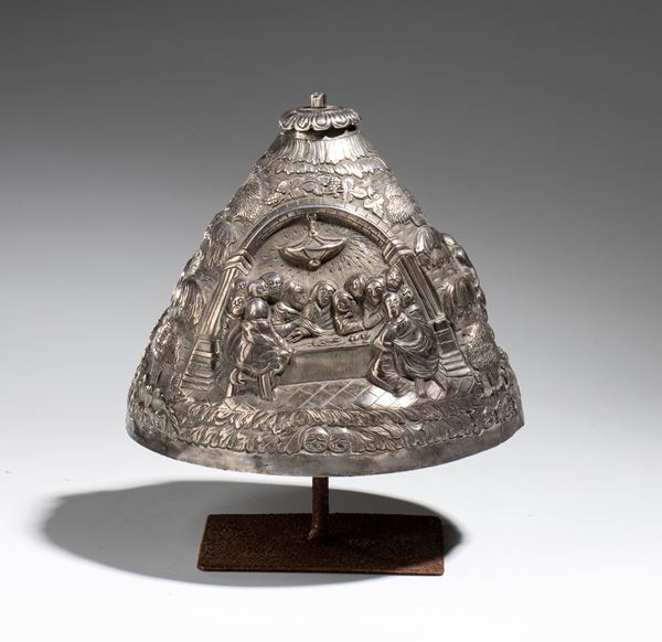 A ciborium lid made of embossed and engraved silver depicting scenes from the life of Christ