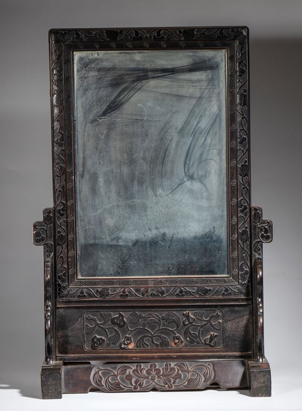 A finely carved table mirror with floral and geometric motifs. China, late Qing Dynasty, 20th century.