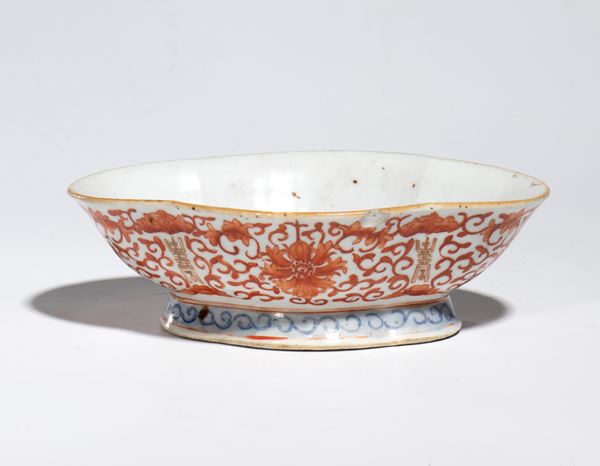 A polychrome enameled porcelain stand decorated with floral motifs in iron red. China, late 19th-20th century.