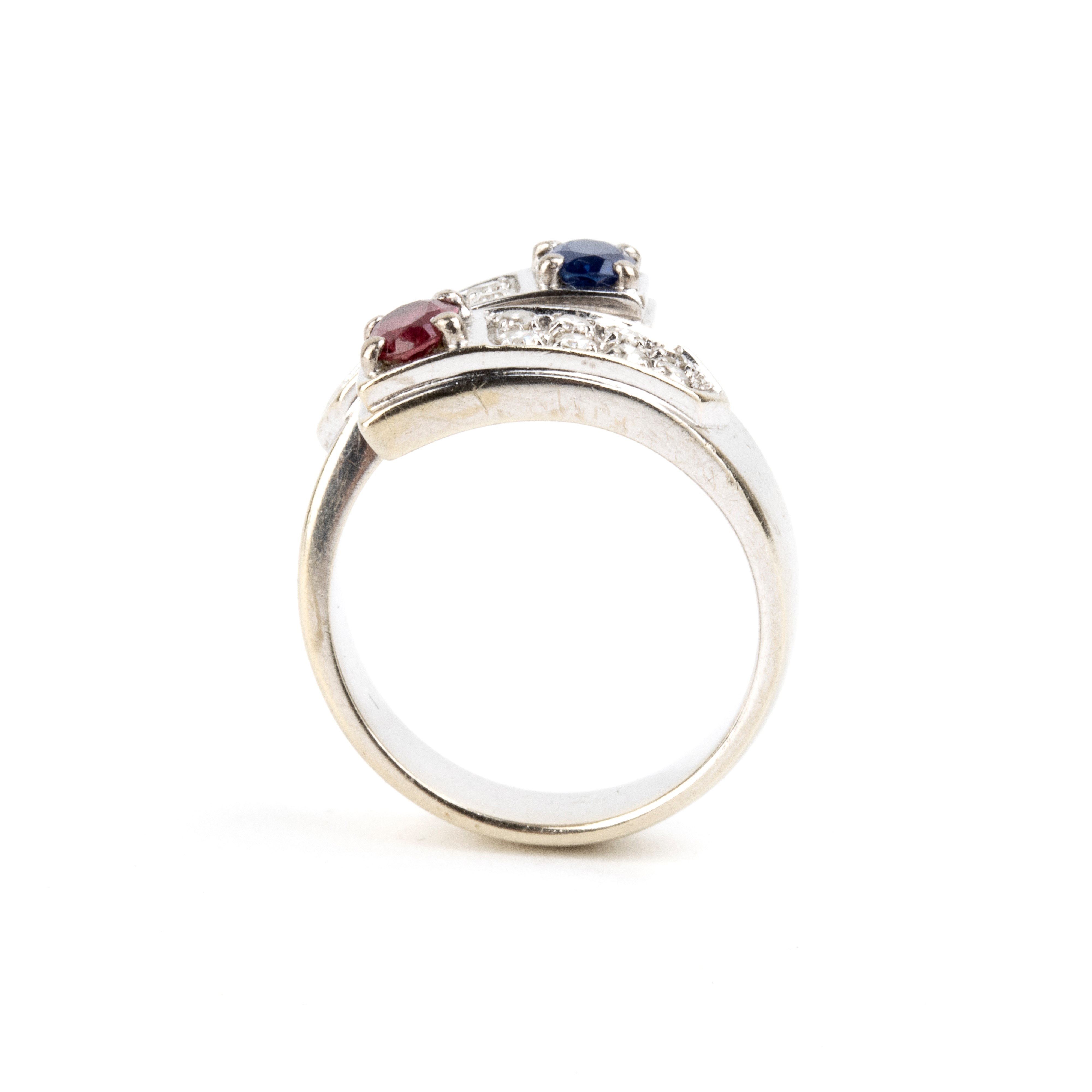 Anello in oro bianco 18k con rubino, zaffiro e diamanti pavé
