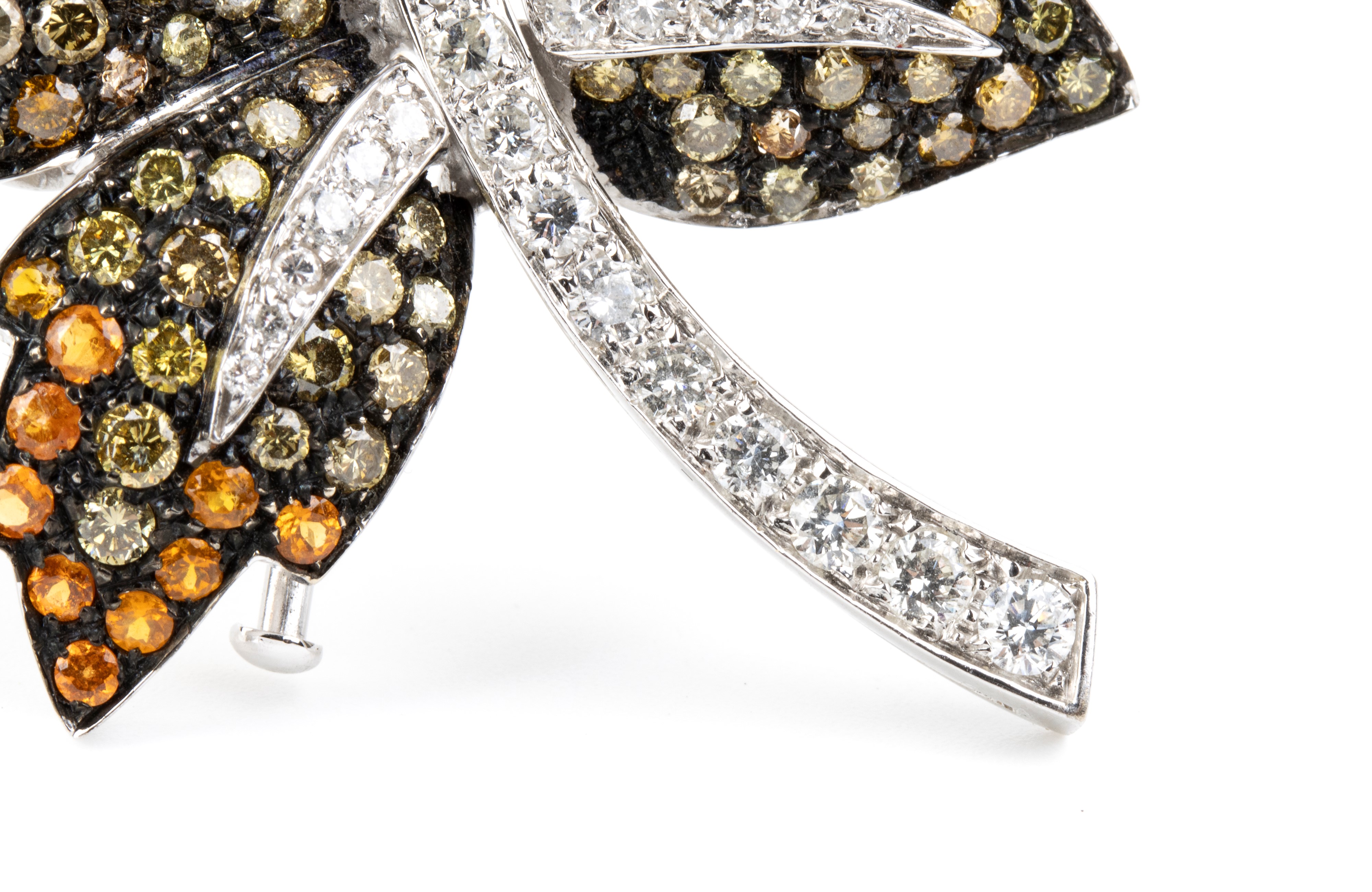 Spilla in oro bianco 18k, modello foglia con pavé di diamanti e corindoni arancio