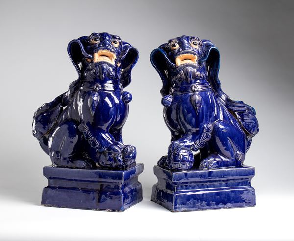 A large pair of dark blue glazed ceramic Foo dogs. China, late 19th-20th century.