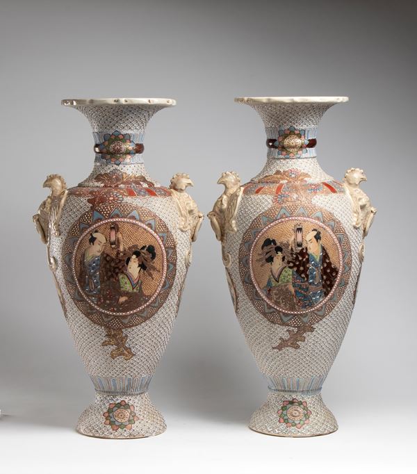  Coppia di vaso Satsuma in ceramica con collo svasato e  anse, decorati a rilievo a fitti decori policromi e scene centrali. Giappone, XX secolo 