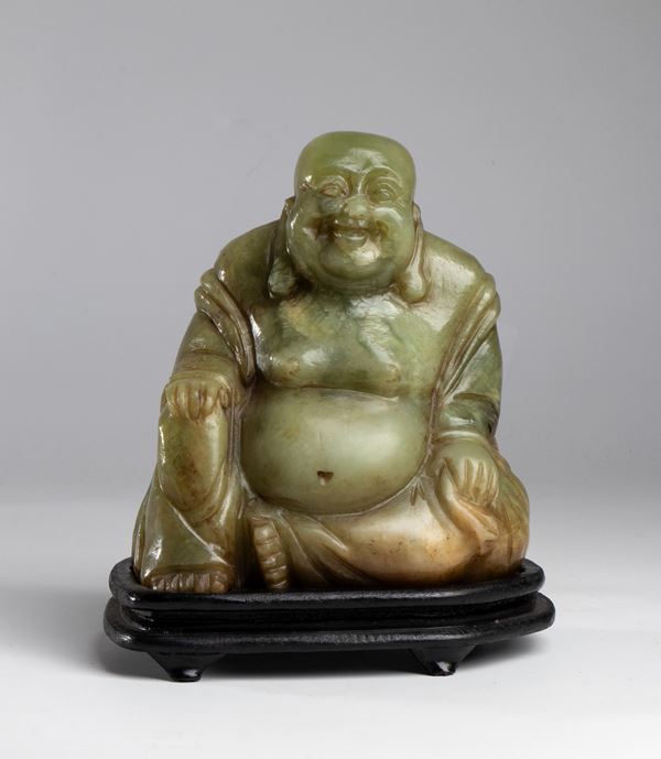 buddha in pietra saponaria con base in legno. Cina, XX secolo