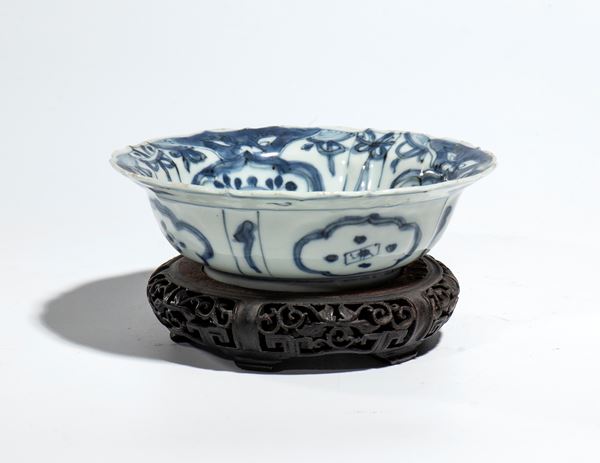 A blue and white porcelain bowl with a naturalistic decoration and a central depiction of a bird in a landscape. China, Ming Dynasty, 17th century.