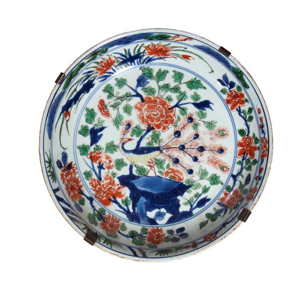 A porcelain plate painted with polychrome enamels depicting phoenixes and peacocks amidst rocks. China, Qing Dynasty, 17th–18th century.