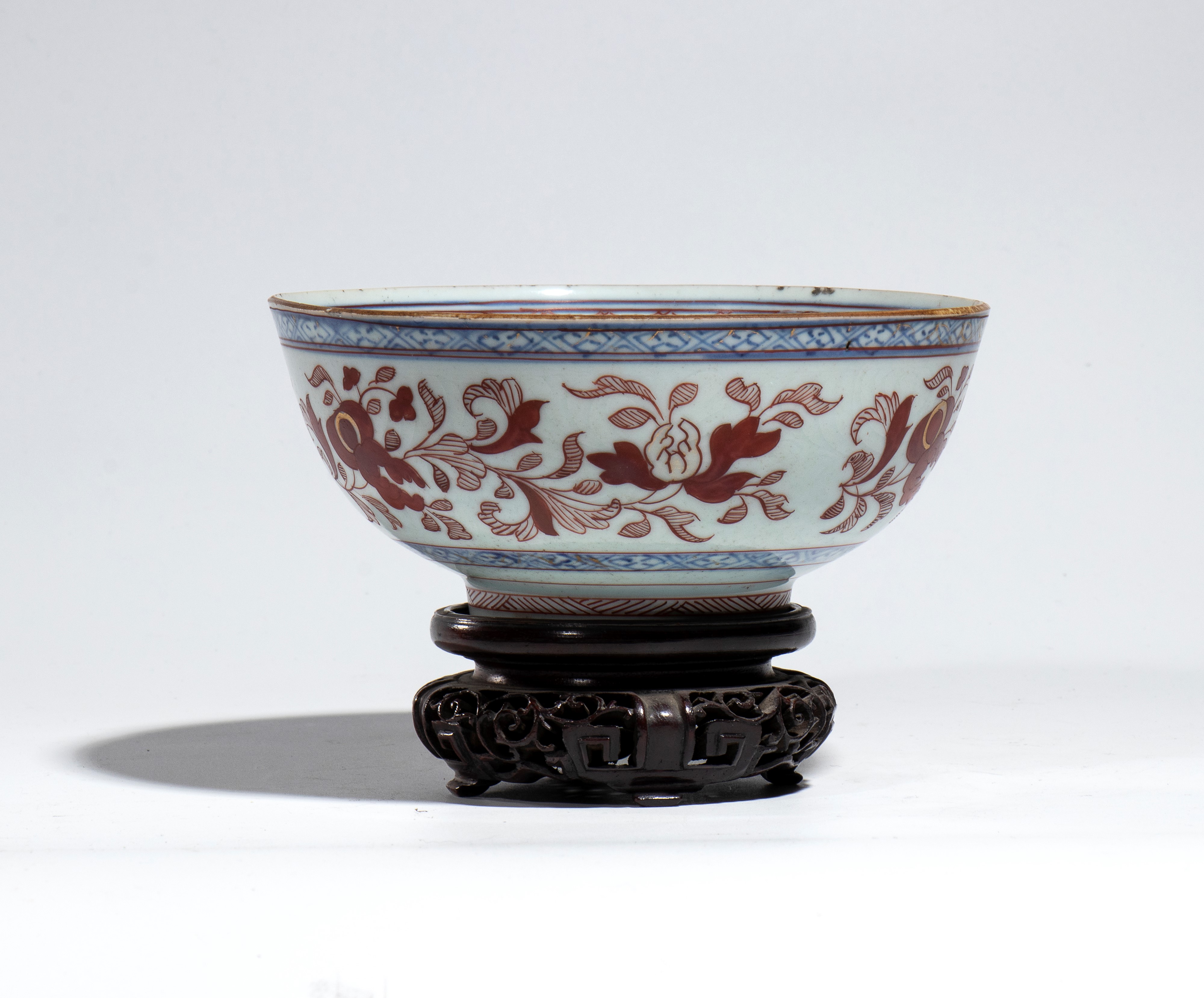 Cina, Ciotola da esportazione in porcellana decorata in blu cobalto e rosso ferro, peonie stilizz...