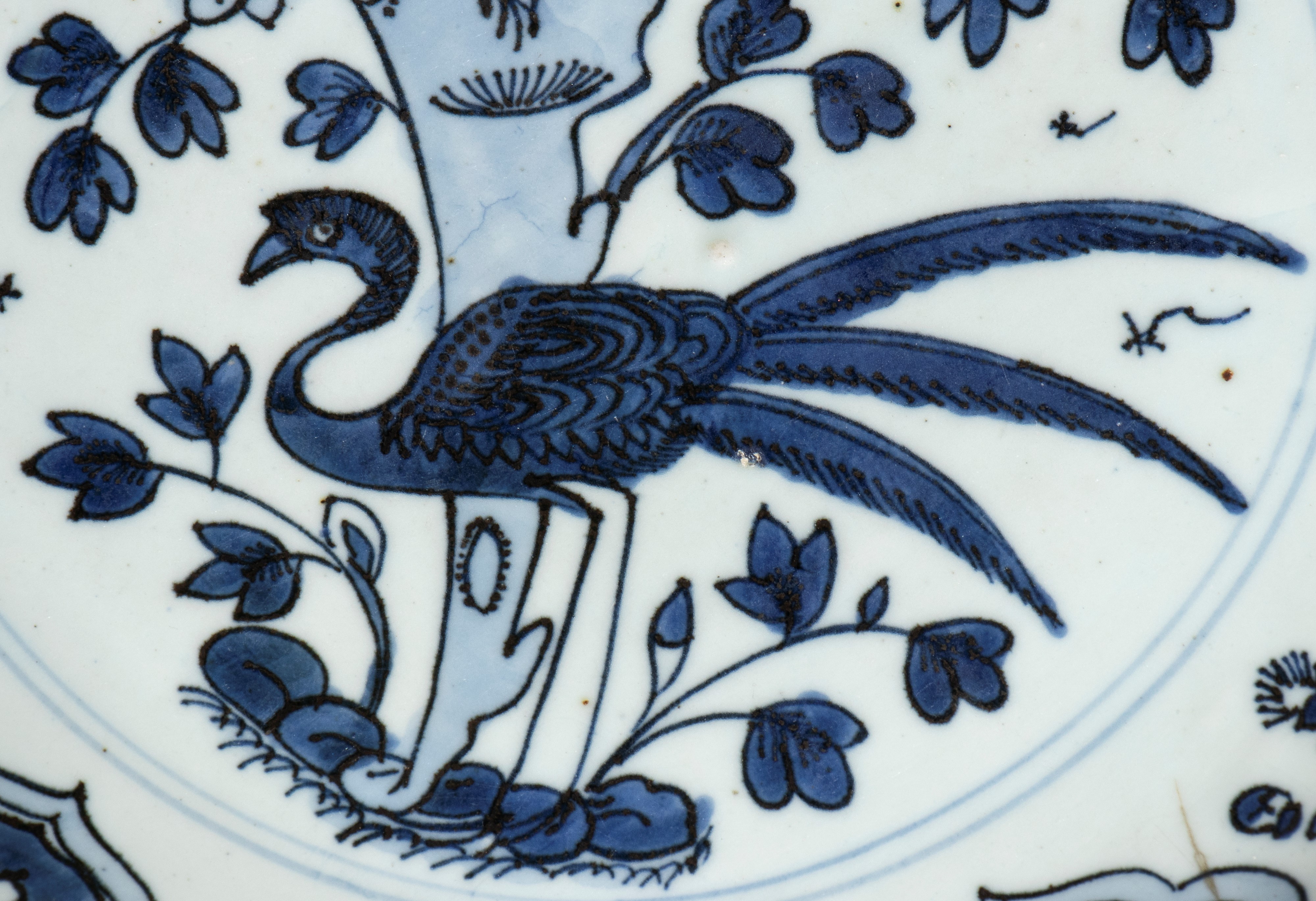 Cina, Piatto in porcellana Kraak bianca e blu con decorazione a fenici, rami e motivi floreali, d...